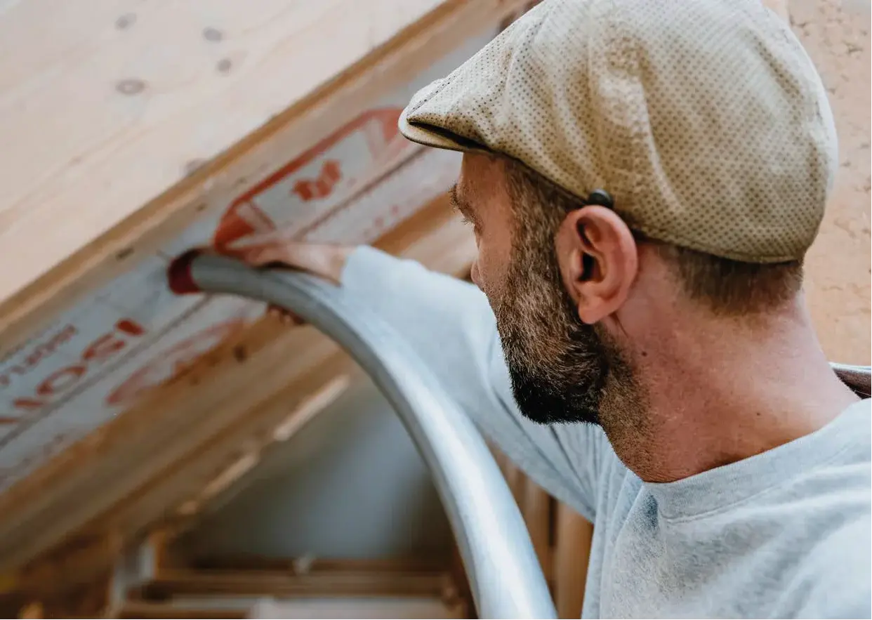 Industriehalle mit automatisierter Einblasmaschine über Holzbauteilen für isofloc Zellulosedämmung
